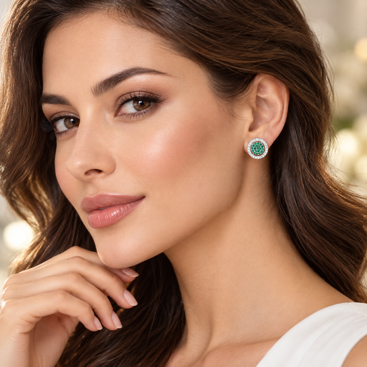 Cercei dama din argint 925 rodiat cu Diamante CZ albe claritate AAAAA si Smaralde CZ verzi la urechea unui model feminin elegant