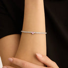 bratara tennis din argint 925 rodiat cu diamante cz albe si diamant cz inima roz purtata la incheietura mainii