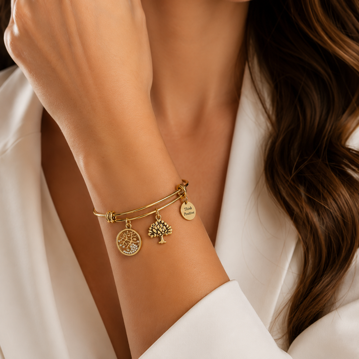 bratara rigida think positive din otel inoxidabil 316 L hipoalergenic auriu cu charmsuri pomul vietii si cristale swarovski la mana unui model feminin elegant
