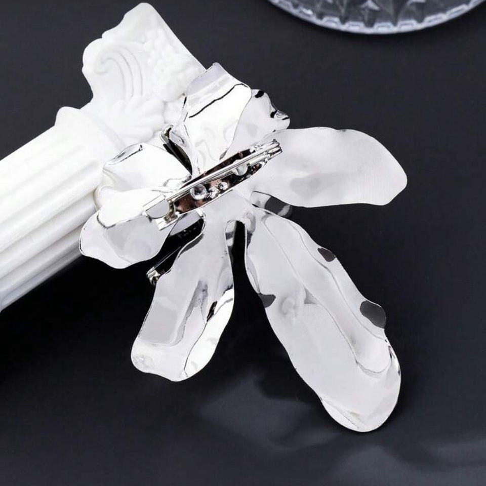 inchidere cu ac de siguranta Brosa mare din metal argintiu in forma de floare sculpturala cu petale lucioase, pistil negru si cristale albe