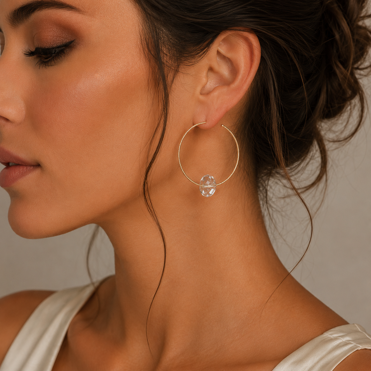 cercei rotunzi din argint 925 rodiat rose gold cu cristal alb la urechea unui model feminin elegant