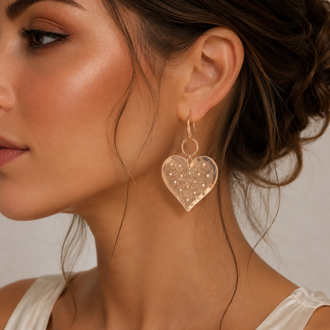 cercei din argint 925 rodiat rose gold cu inimi dantelate diamante cz albe la urechea unui model feminin elegant