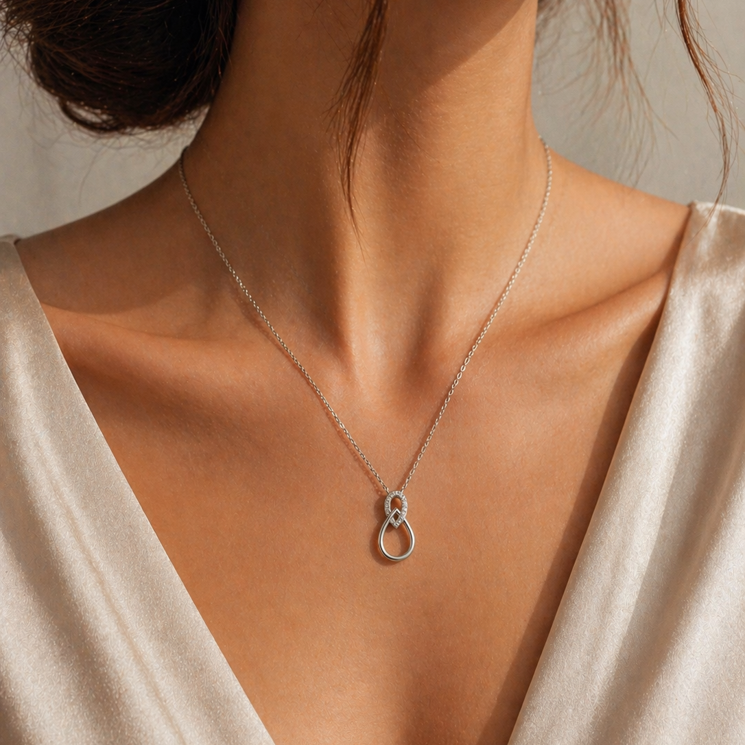 Colier elegant din argint 925 rodiat cu pandantiv sculptural format din doua bucle intrepatunse si diamante CZ stralucitoare, colectia Lasardo Gioielli, la gat