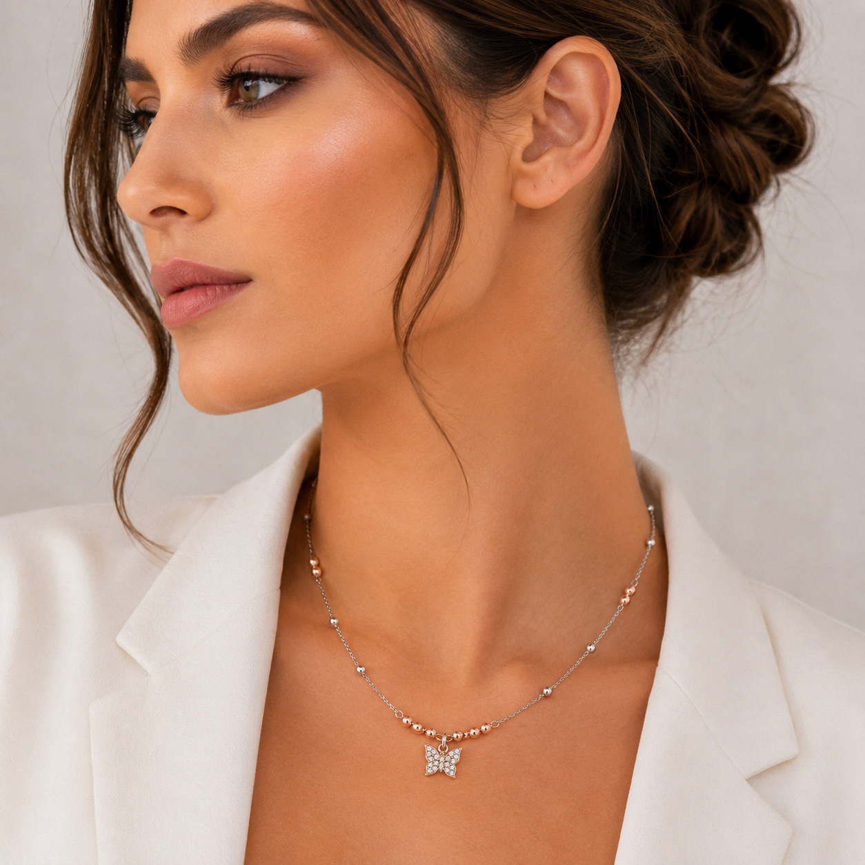 Colier de dama din argint 925 rodiat cu elemente sferice bicolore si pandantiv fluture stralucitor cu diamante cz la gatul unui model