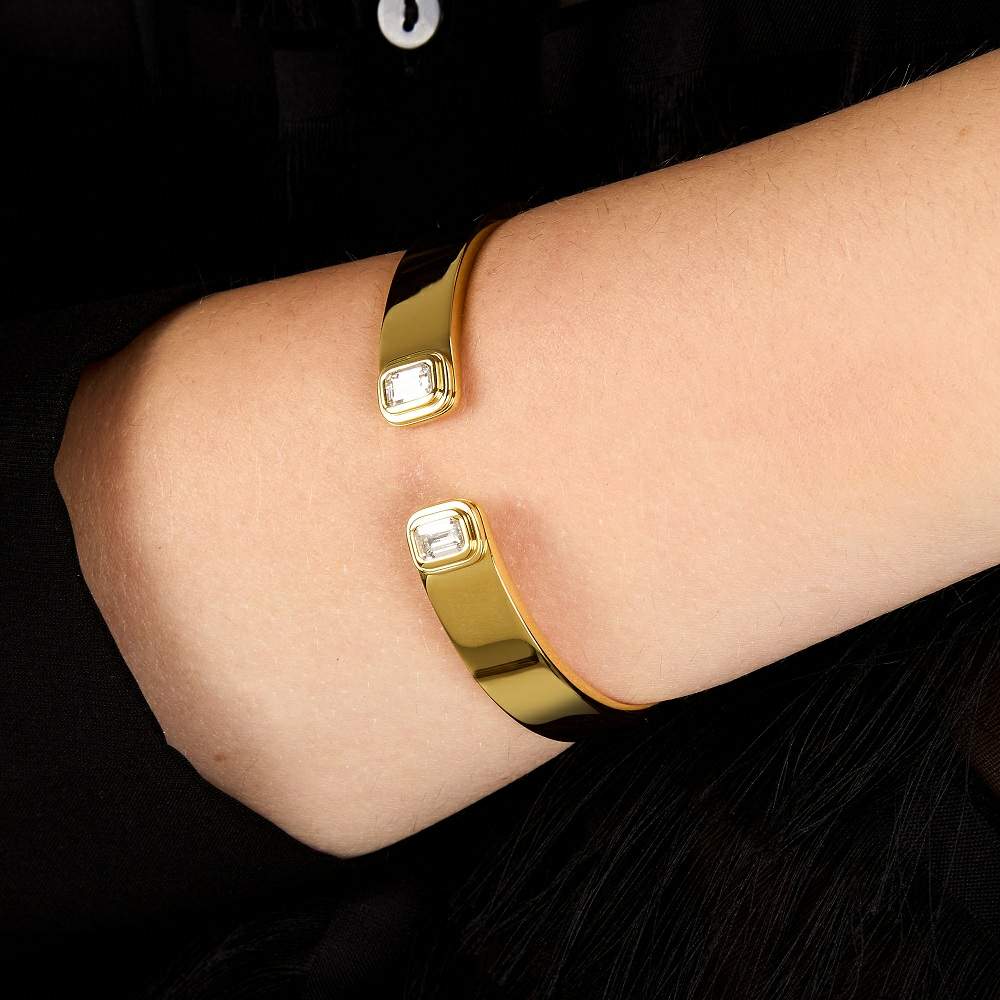  Bratara rigida din otel rodiat auriu Trussardi cu deschidere frontala si doua diamante cz dreptunghiulare. la mana unui model feminin