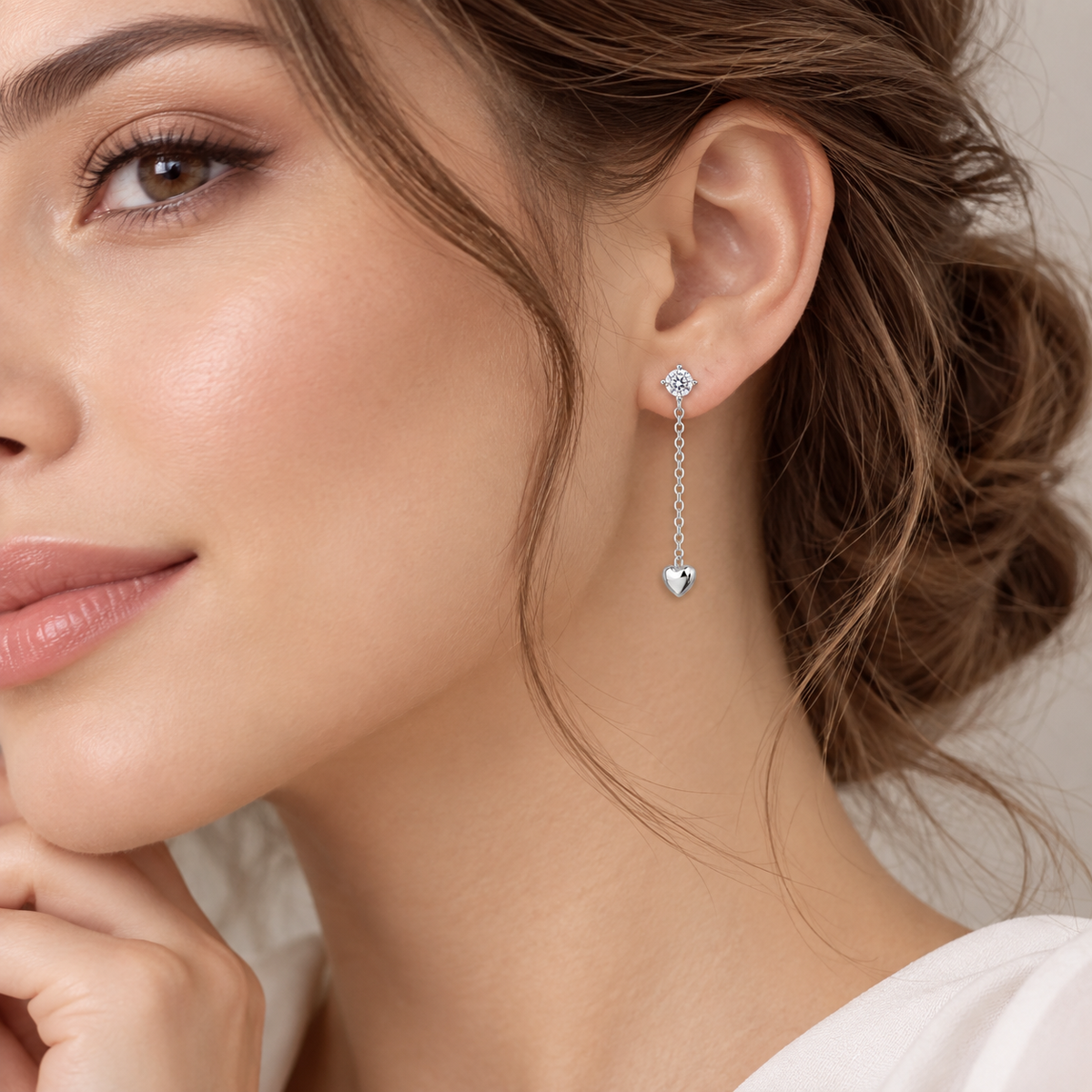Cercei dama din argint 925 rodiat cu diamante CZ albe claritate AAAAA si inimioara la urechea unui model feminin elegant