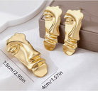 Set premium de dama din metal placat auriu compus din cercei si brosa in forma de masca abstracta suprarealista dimensiune 7,5 cm * 4 cm
