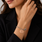 Detaliu la incheietura unei femei purtand bratara din argint cu medalion rose gold gravat Super Mom si mic clopotel din argint rodiat.