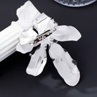 inchidere cu ac de siguranta Brosa mare din metal argintiu in forma de floare sculpturala cu petale lucioase, pistil negru si cristale albe