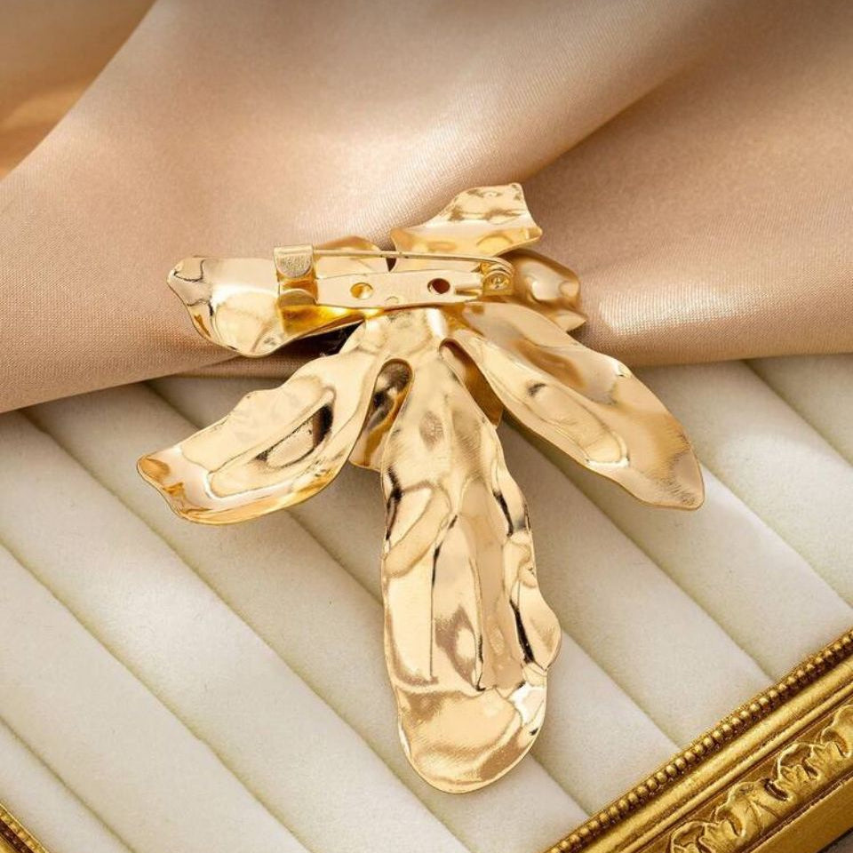 inchidere cu ac de siguranta pentru Brosa mare din metal auriu in forma de floare sculpturala cu petale lucioase, pistil negru si cristale albe