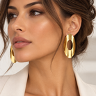 Cercei dama aurii statement din metal placat hipoalergenic, model oval decupat 7.6 cm la urechea unui model feminin elegant