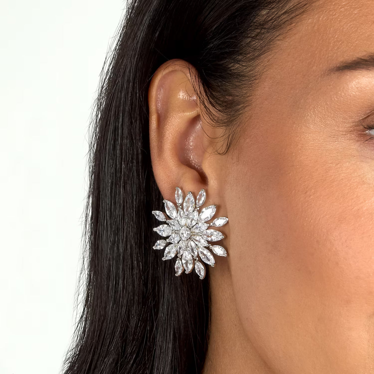 Pereche de cercei de dama Morellato Riflessi din argint 925 sub forma de floare tridimensionala cu pavaj din cristale cz marquise, la urechea unui model feminin elegant