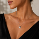 Colier din argint 925 cu un pandantiv central in forma de inima, acoperit in intregime cu un pavaj dens de diamante cz albe stralucitoare la gatul unui model feminin elegant