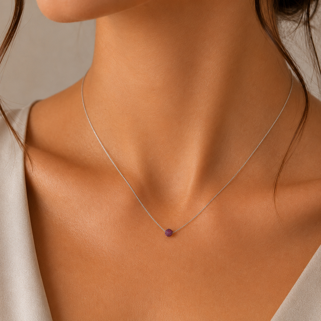 Model feminin purtand colierul fin din argint rodiat cu pandantiv rotund din cristale swarovski mov la baza gatului.