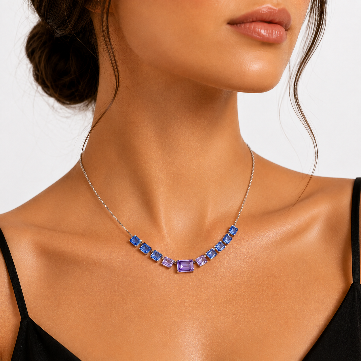 colier din argint 925 rodiat cu tanzanite mov si albastre la gatul unui model feminin elegant