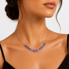 colier din argint 925 rodiat cu tanzanite mov si albastre la gatul unui model feminin elegant