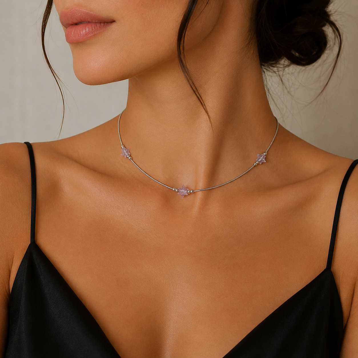  Colier rigid si fin din argint 925 rodiat cu trei elemente in forma de stea realizate din cristale fatetate in nuanta lila deschis la gatul unui model feminin elegant