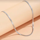  Colier de dama Herringbone lat de 3mm din otel inoxidabil placat PVD cu rodiu, expus pe fundal roz