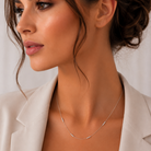 Model feminin purtand un colier lung din argint 925 rodiat peste o tinuta eleganta de zi evidentiind finisajul stralucitor al sferelor.