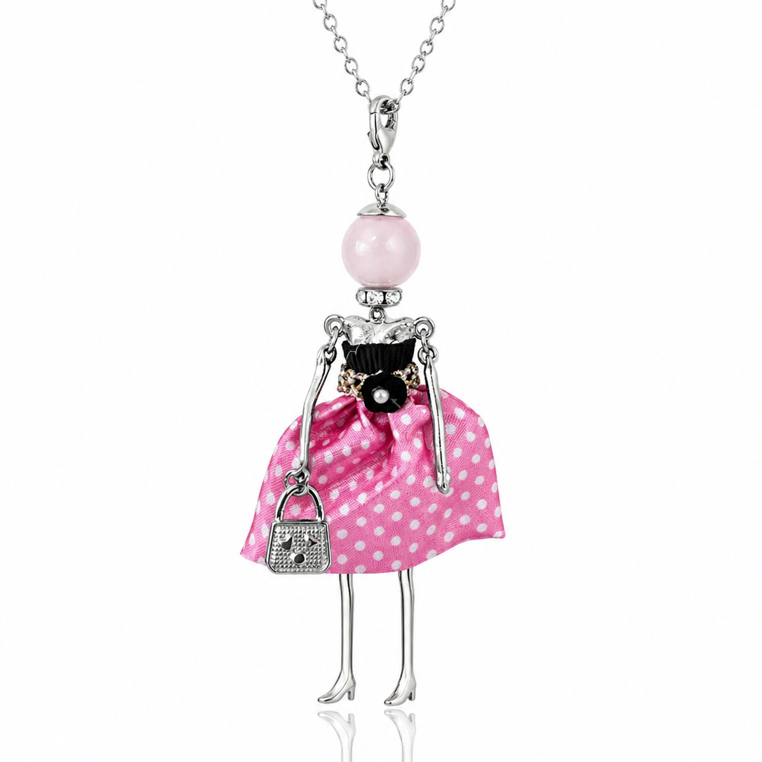 Colier lung din otel inoxidabil cu pandantiv din colectia Bambole, papusica cu rochita roz cu buline albe, gentusa argintie si cap din perla roz.
