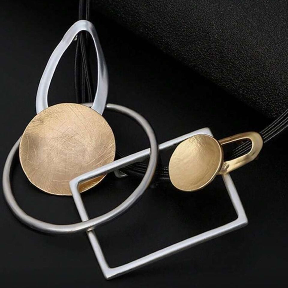 colier modern cu cercuri si patrate metalice pe snur dublu din piele neagra pe fundal negru