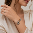Model feminin purtand setul de bratari rigide din argint cu cristal inima, accesorizate elegant la o tinuta de zi.